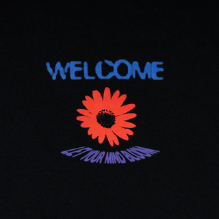 Up close view of front welcome logo. Let your mind bloom below daisy.